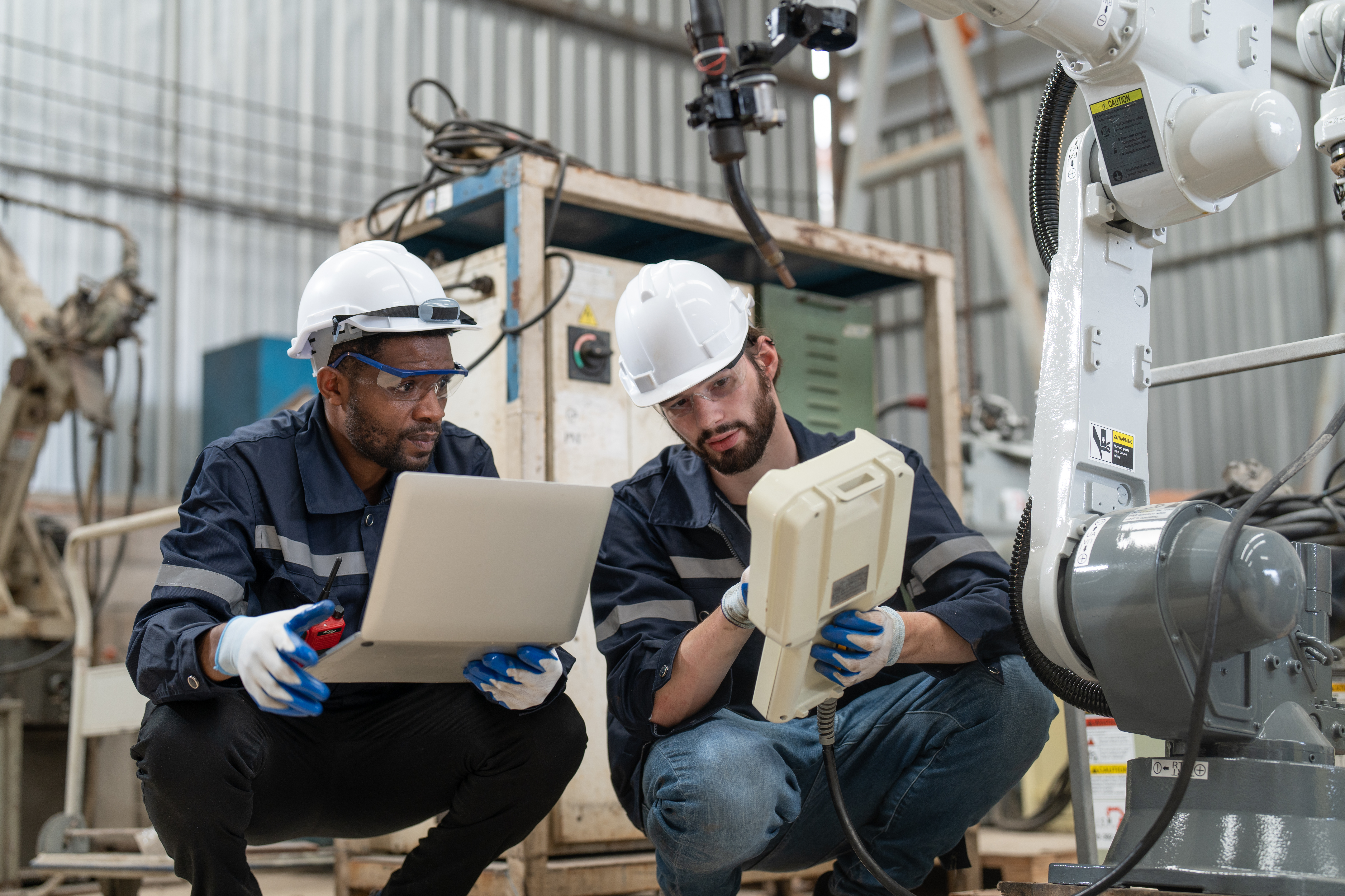 male-engineers-using-laptop-remote-control-inspection-robot-arm-welding-machine-factory (1)
